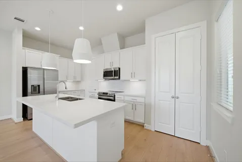 a kitchen with white cabinets and stainless steel appliances