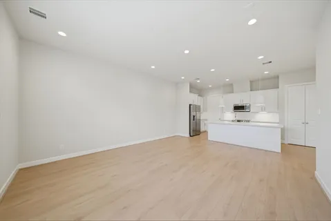 a view of kitchen with kitchen island a sink wooden floor and kitchen island