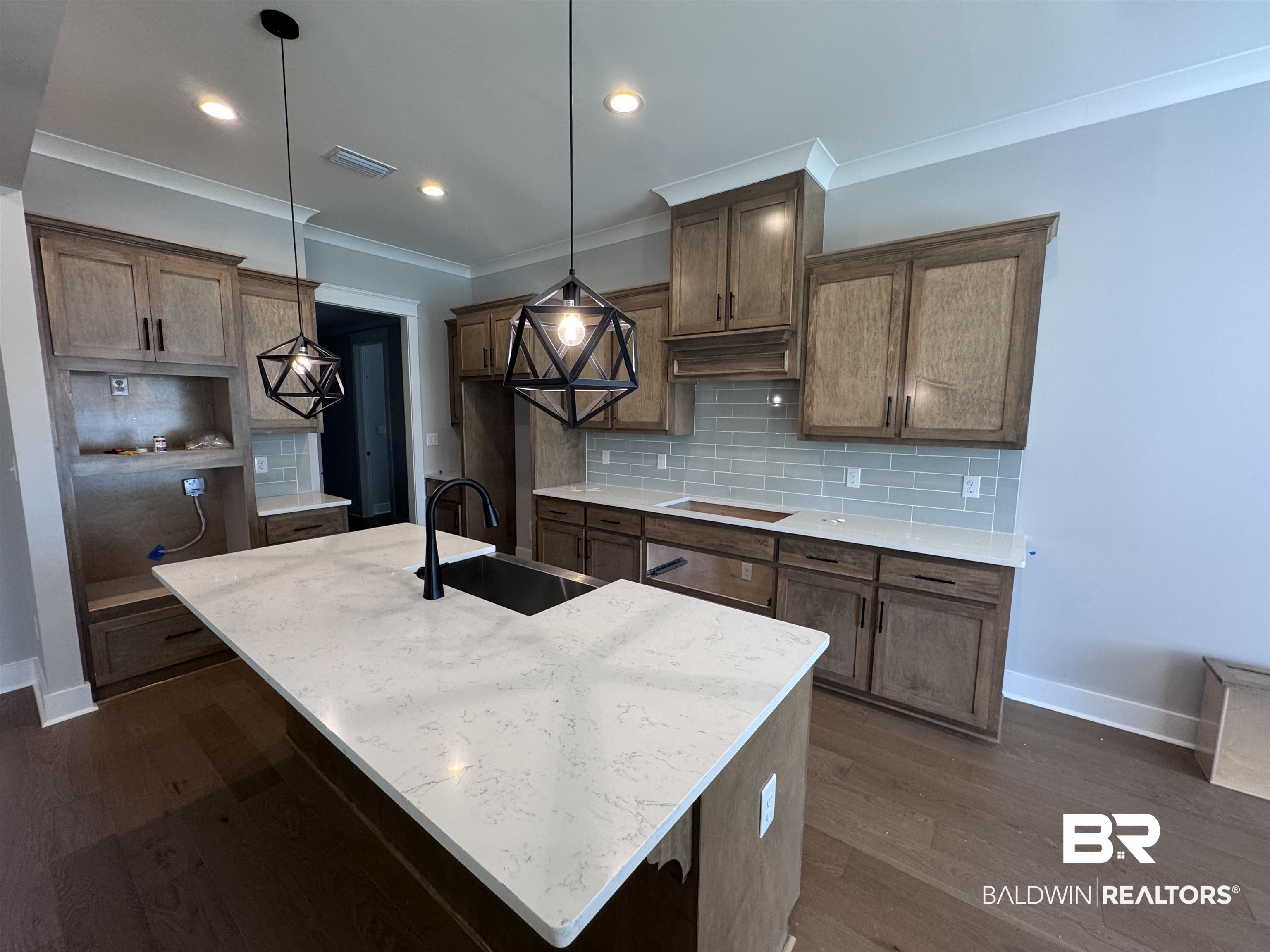 27371 Patch Pl Loop Daphne, AL 36526 - Photo 20 of 63 Kitchen with a center island with sink, dark wood finished floors, backsplash, decorative light fixtures, and light stone counters