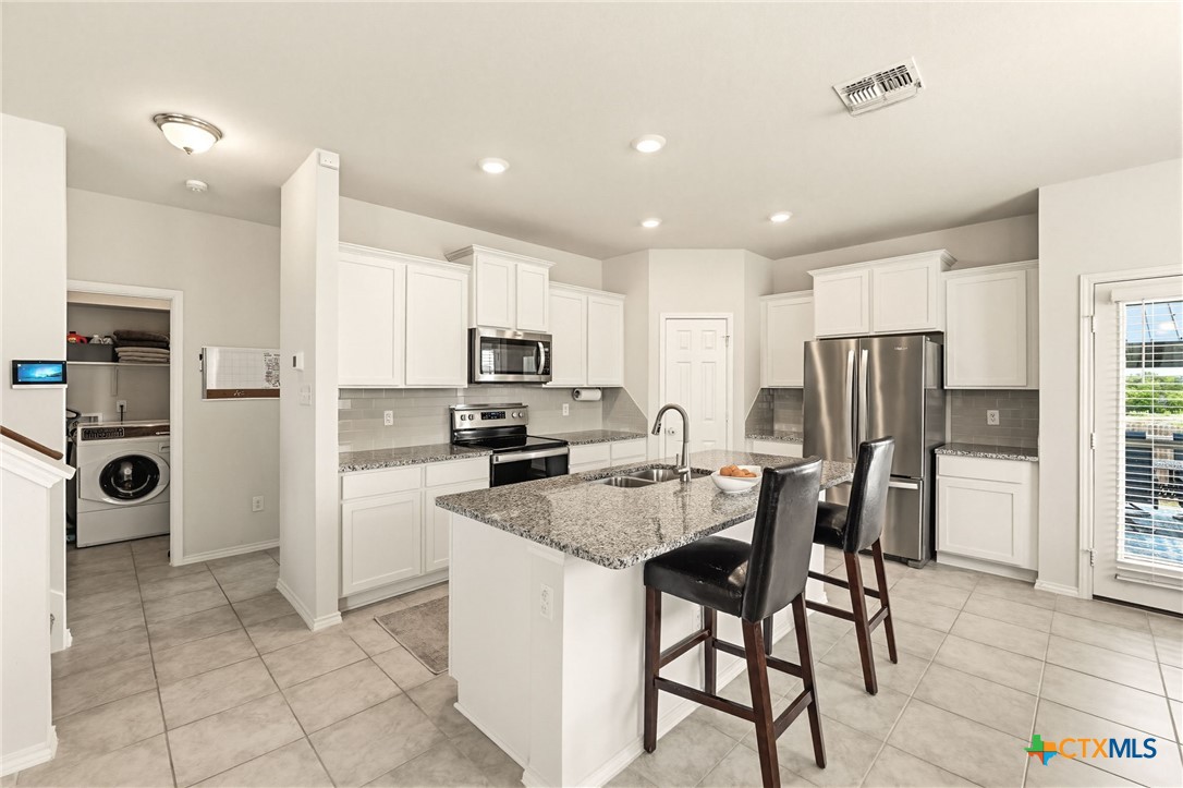2044 Mallard Court Copperas Cove, TX 76522 - Photo 9 of 41 a kitchen with stainless steel appliances granite countertop a refrigerator a sink a stove a dining table and chairs