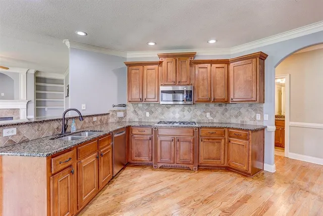 a kitchen with stainless steel appliances granite countertop a sink stove and cabinets