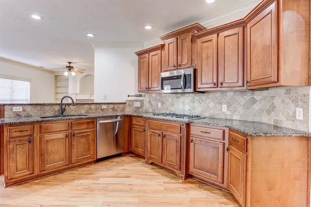 a large kitchen with wooden floors and a fireplace