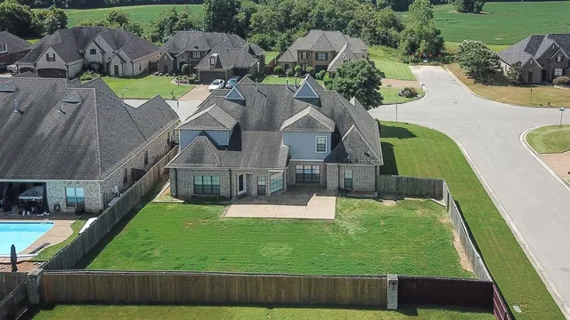 an aerial view of a house with swimming pool garden and patio
