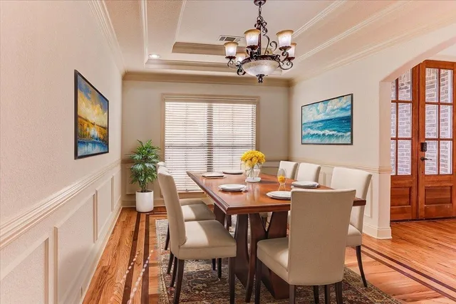 a view of a dining room with furniture a chandelier and wooden floor