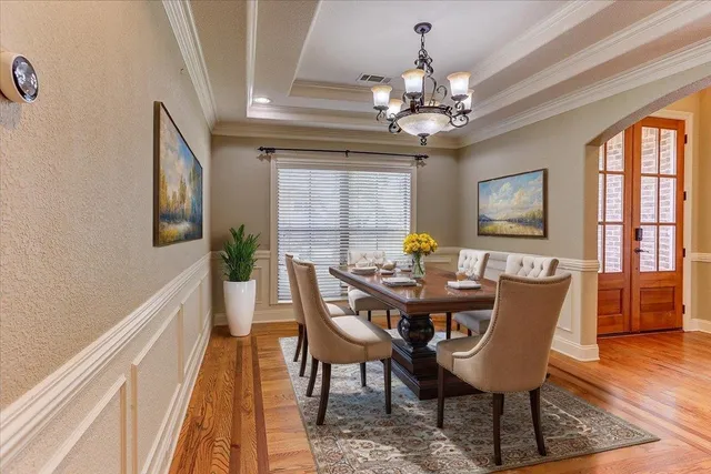 a view of a dining room with furniture a chandelier and wooden floor