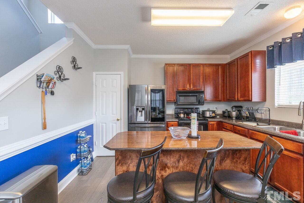 6012 Ladish Lane Raleigh, NC 27610 - Photo 12 of 29 a kitchen with a table chairs sink and cabinets
