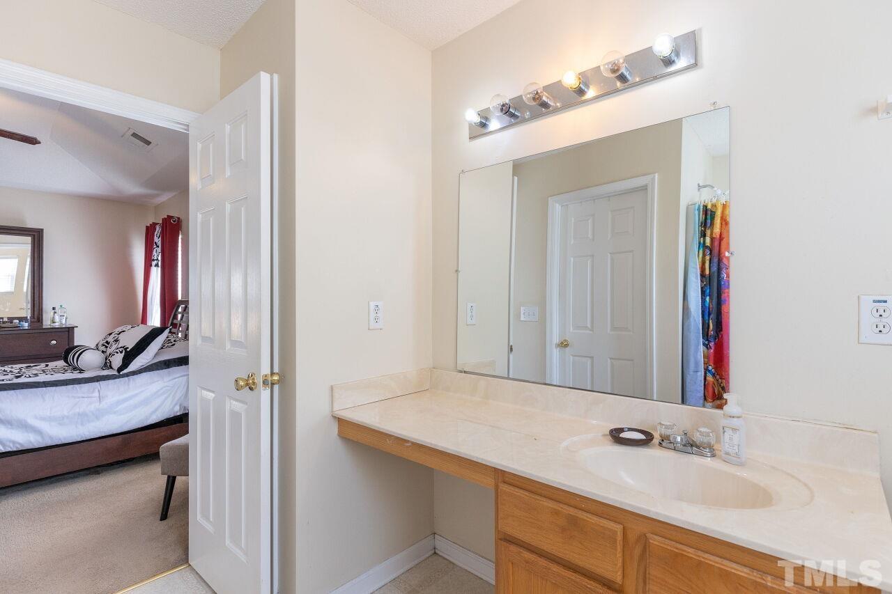 6012 Ladish Lane Raleigh, NC 27610 - Photo 20 of 29 a en suite bathroom with a sink and a mirror