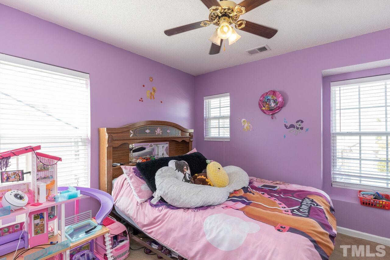 6012 Ladish Lane Raleigh, NC 27610 - Photo 21 of 29 a bedroom with a bed and a chandelier