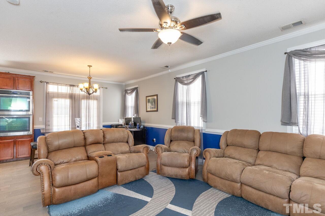 6012 Ladish Lane Raleigh, NC 27610 - Photo 5 of 29 a living room with furniture a large window and a chandelier