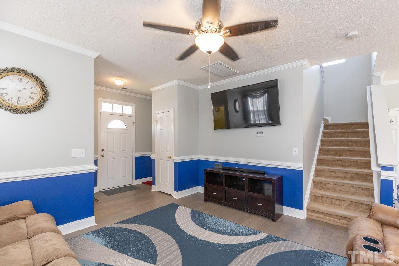 6012 Ladish Lane Raleigh, NC 27610 - Photo 7 of 29 a living room with furniture a fireplace and a flat screen tv