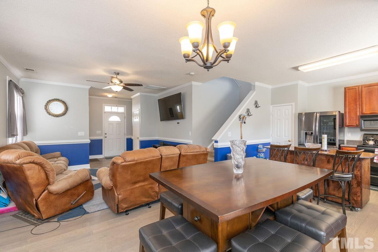 6012 Ladish Lane Raleigh, NC 27610 - Photo 8 of 29 a living room with furniture a chandelier and a flat screen tv