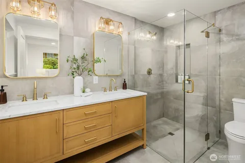 a bathroom with a shower sink vanity and toilet