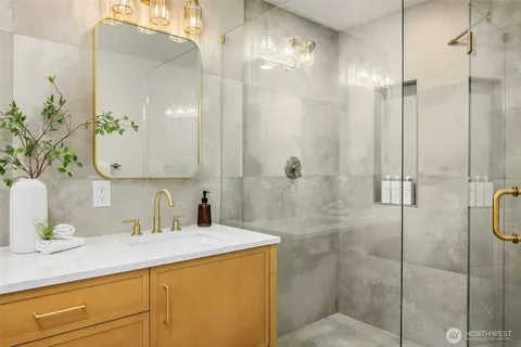 a bathroom with a granite countertop sink a toilet and shower