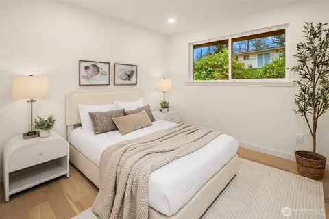 a bedroom with a large bed and a potted plant
