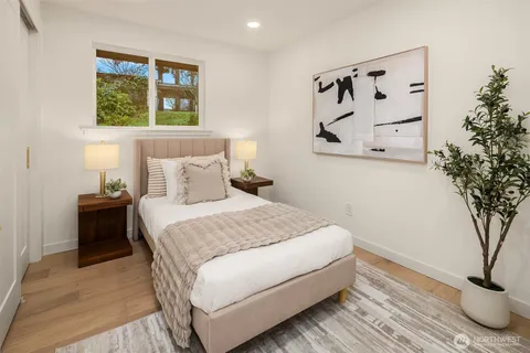 a bedroom with a large bed and a potted plant