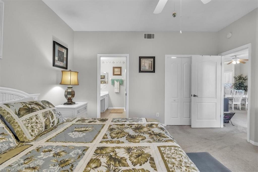 8075 Tiger Cove, Unit 1706 Naples, FL 34113 - Photo 19 of 50 Bedroom featuring a closet, light carpet, and a ceiling fan
