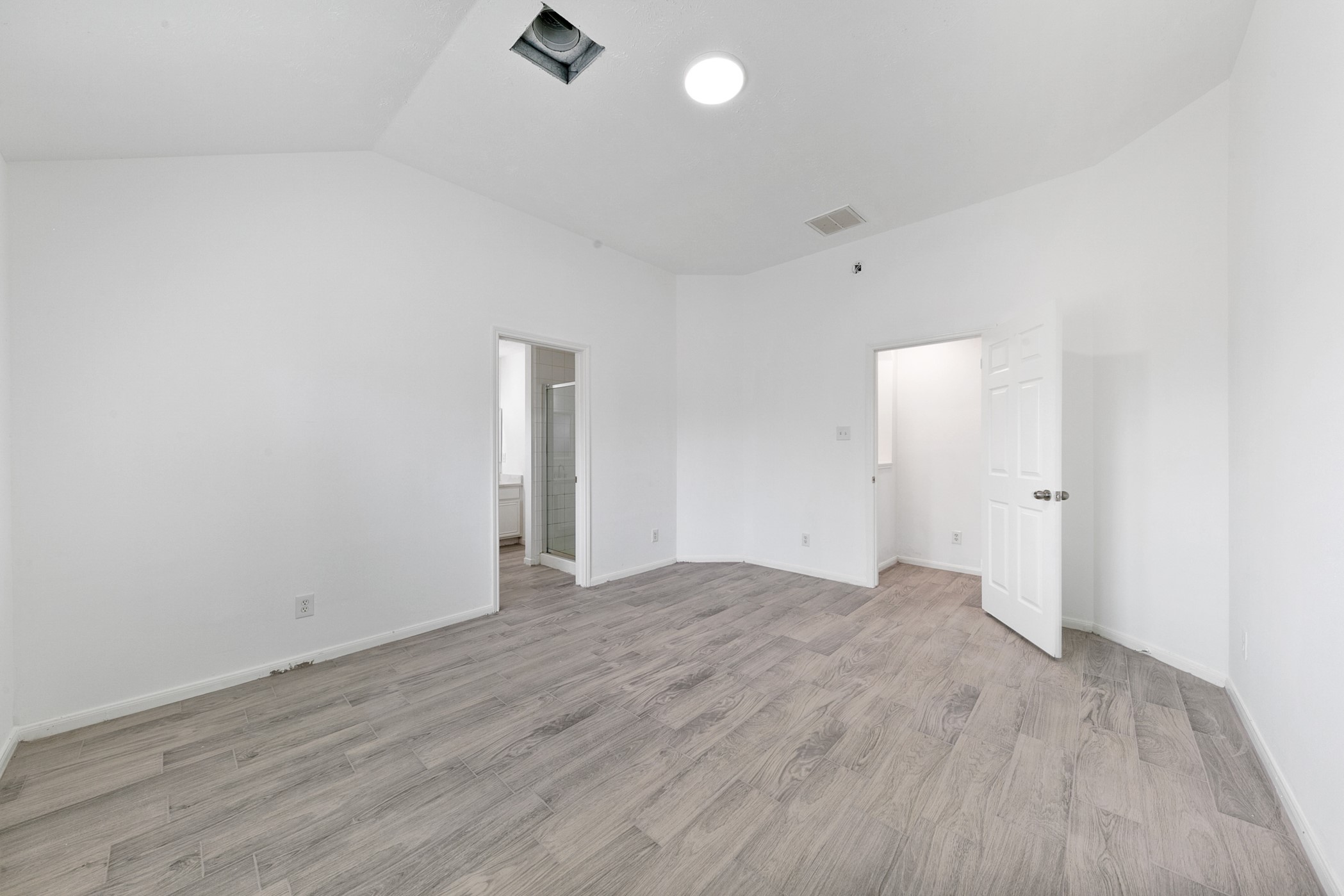 12014 Raven View Drive Houston, TX 77067 - Photo 20 of 29 This room features bright white walls and light wood flooring, creating an open and airy space. It includes a recessed ceiling light and connects to a bathroom, offering convenience and functionality.