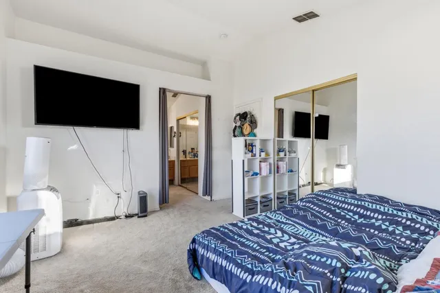 a bedroom with a bed and a flat screen tv