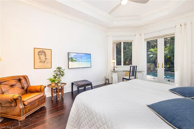 a spacious bedroom with a bed a couch and a potted plant on the dresser
