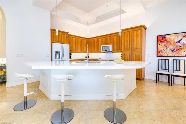 a kitchen with stainless steel appliances granite countertop a sink a stove and a dining table with wooden floor