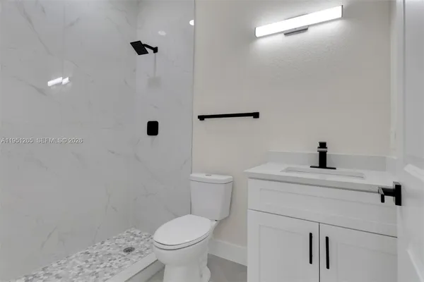 a bathroom with a sink a toilet and a shower