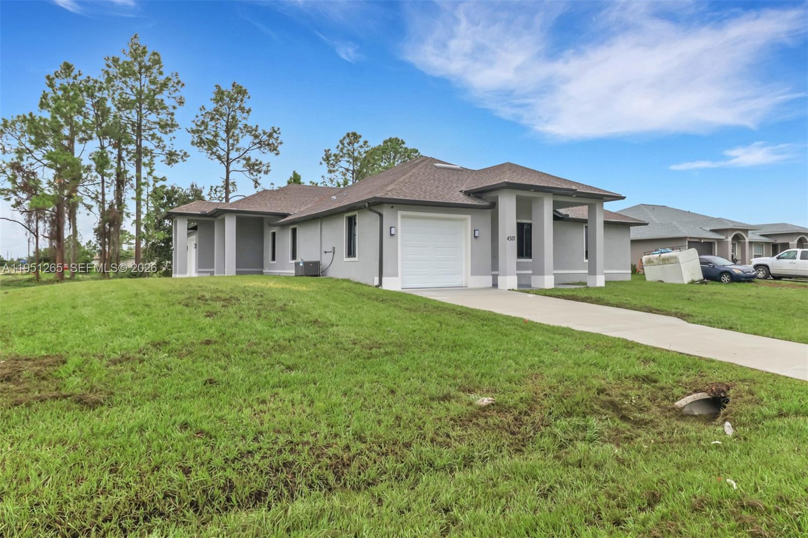 4501 15th Street Southwest, Unit 4501 Lehigh Acres, FL 33973 - Photo 2 of 40 a front view of a house with a garden