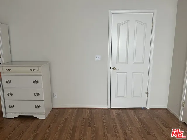 an empty room with wooden floor and closet