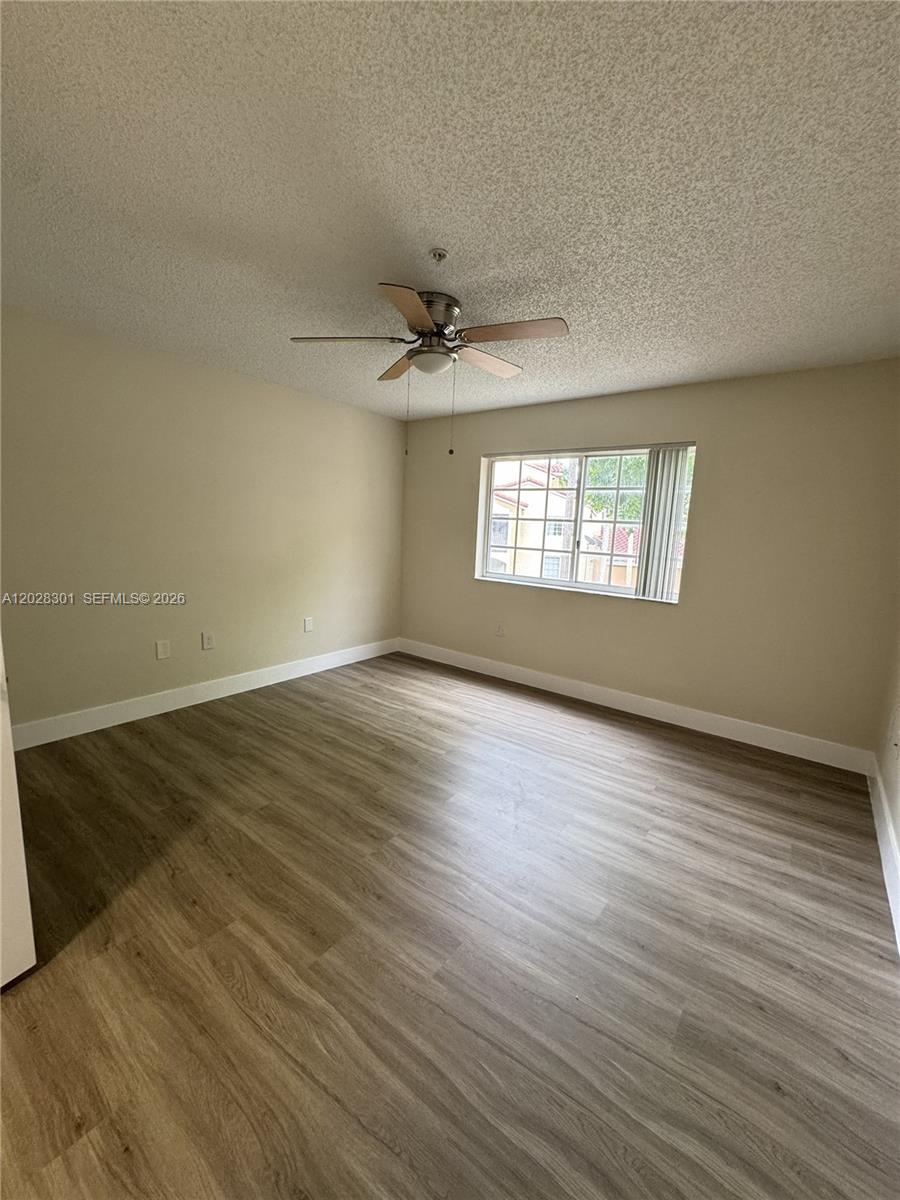 2021 Renaissance Boulevard, Unit 201 Miramar, FL 33025 - Photo 11 of 26 an empty room with wooden floor and windows