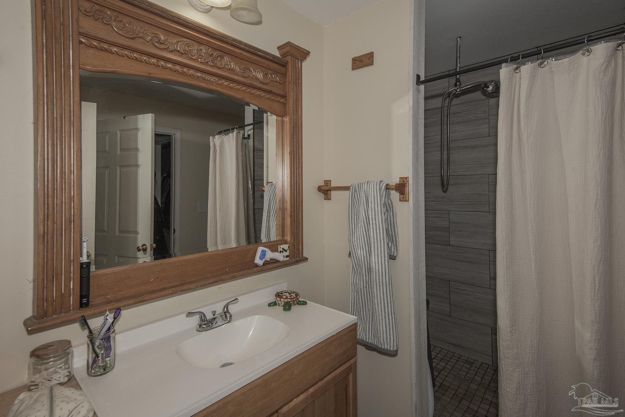 6739 Deception Road Milton, FL 32583 - Photo 19 of 24 a bathroom with a sink and mirror