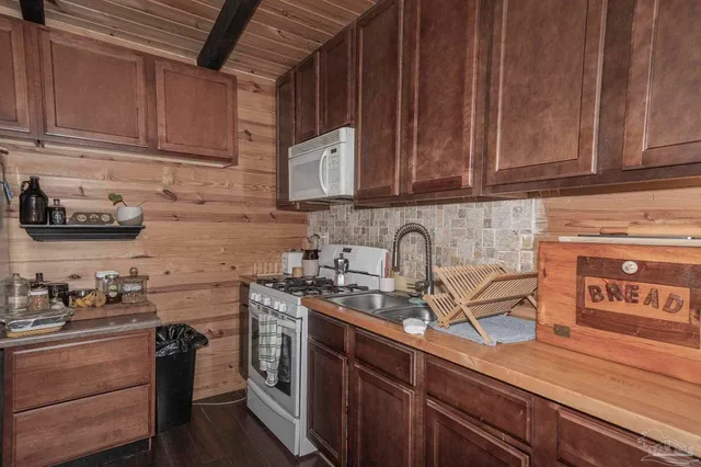 a kitchen with stainless steel appliances granite countertop a sink a stove and cabinets