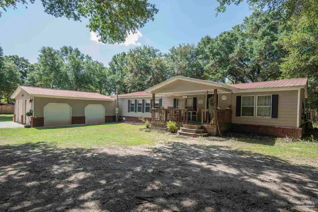 a view of a house with backyard and sitting area