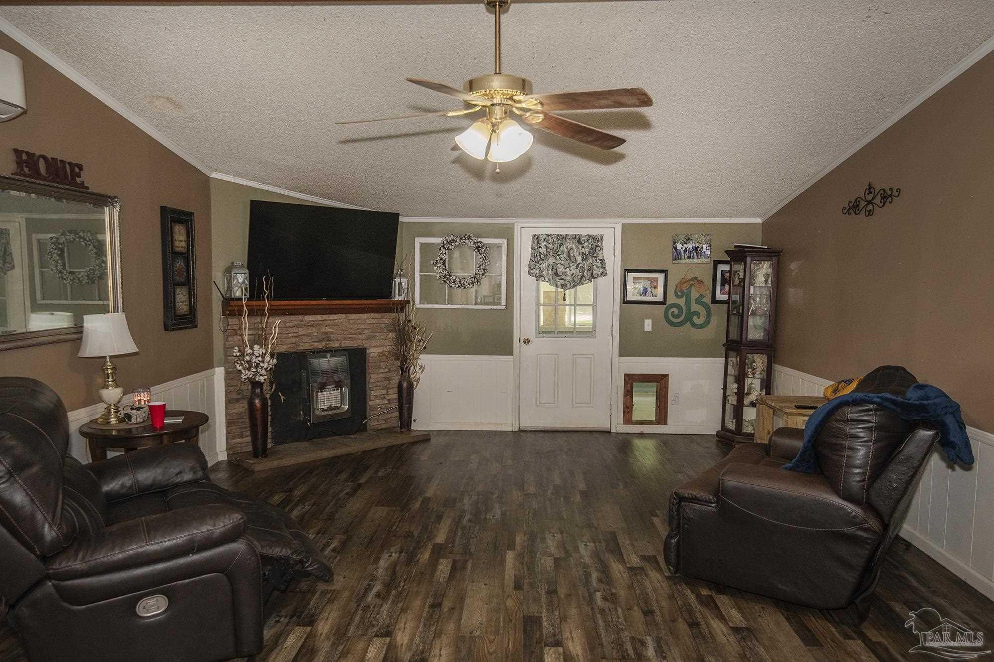 6739 Deception Road Milton, FL 32583 - Photo 5 of 24 a living room with furniture a flat screen tv and a fireplace