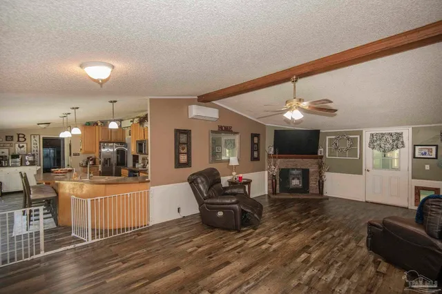 a living room with furniture a fireplace and a flat screen tv