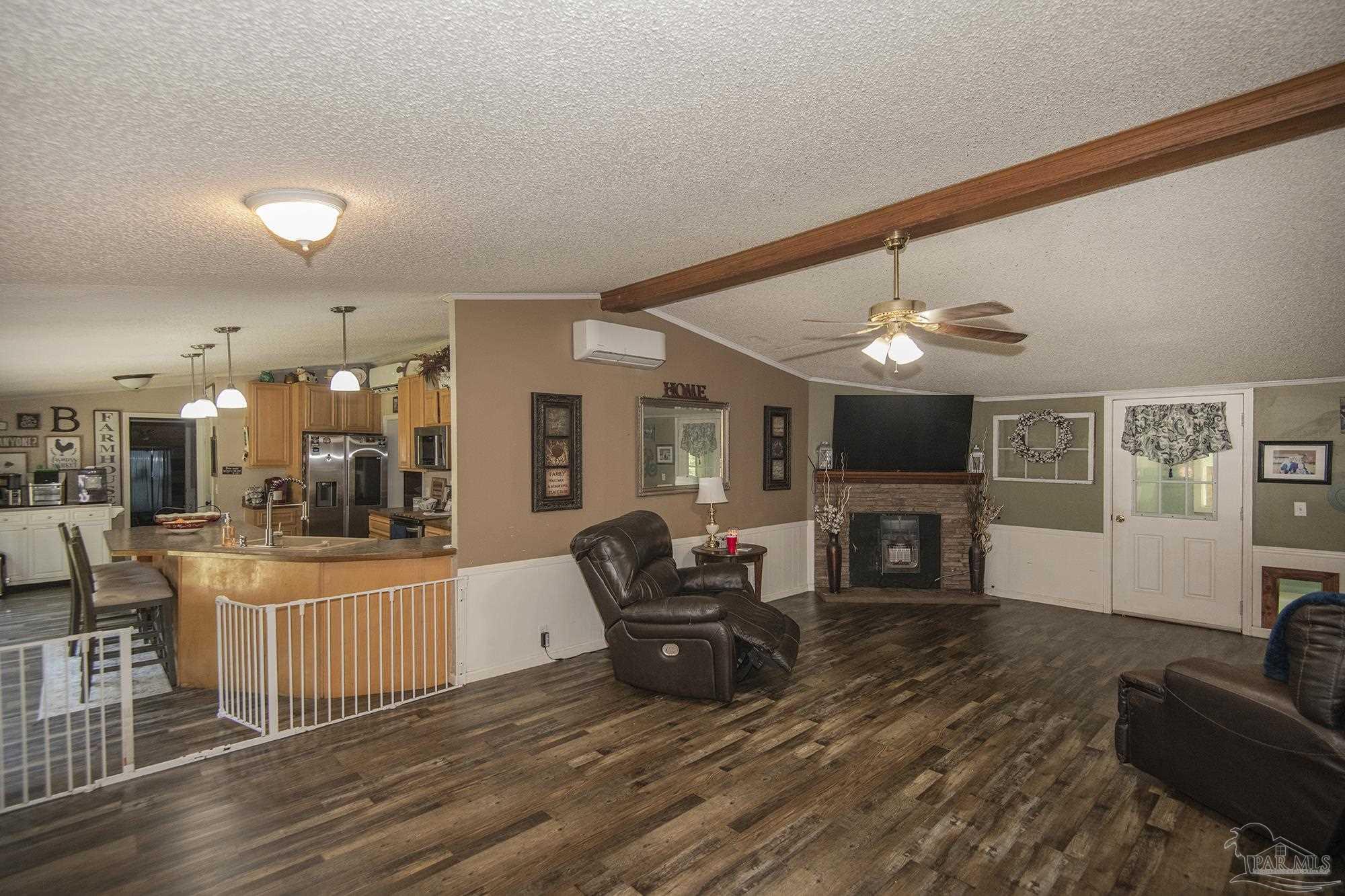 6739 Deception Road Milton, FL 32583 - Photo 6 of 24 a living room with furniture a fireplace and a flat screen tv