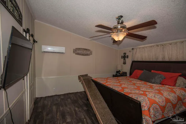 a bedroom with a bed and a flat tv screen on the dresser