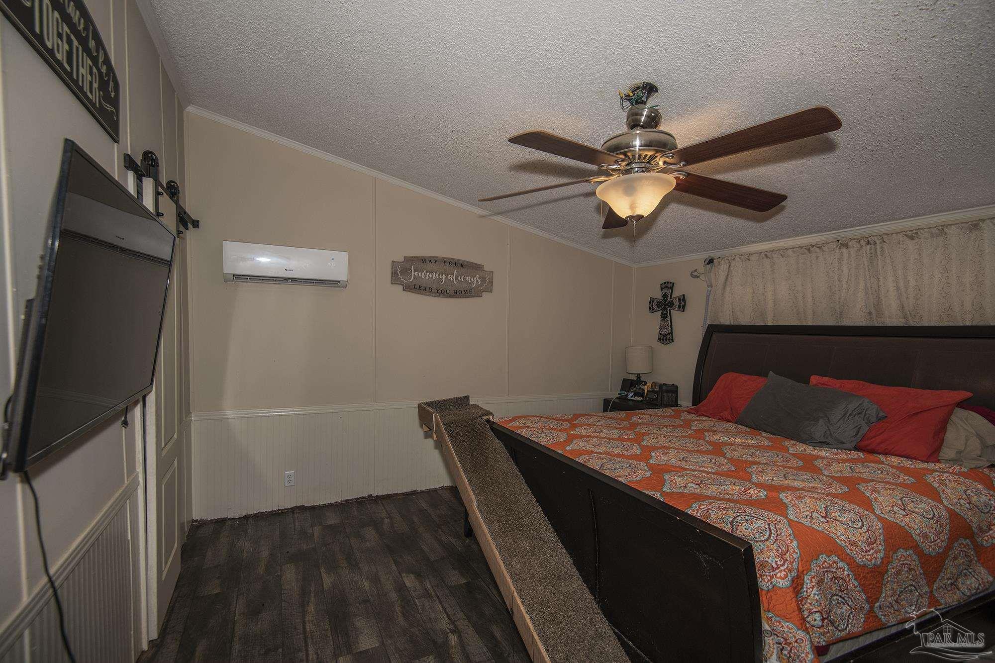 6739 Deception Road Milton, FL 32583 - Photo 9 of 24 a bedroom with a bed and a flat tv screen on the dresser