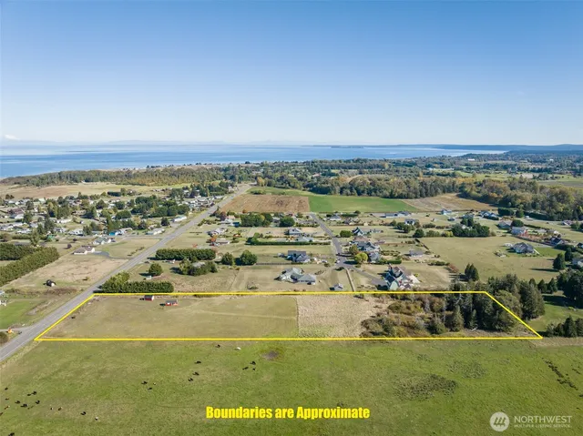 a kitchen with stainless steel appliances kitchen island a table chairs in it and wooden floors