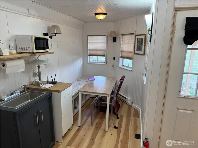 a view of a wooden house with a yard and wooden fence