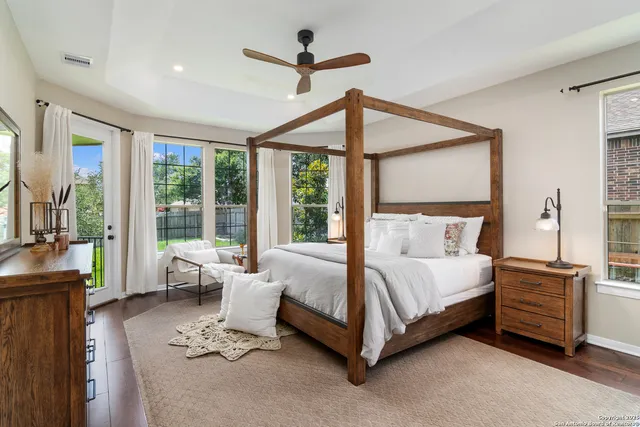 a bedroom with a bed large window and a chandelier