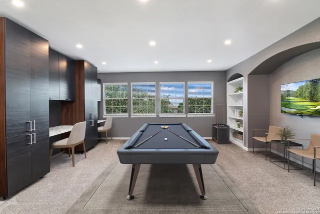 a sitting area with pool table and glass windows