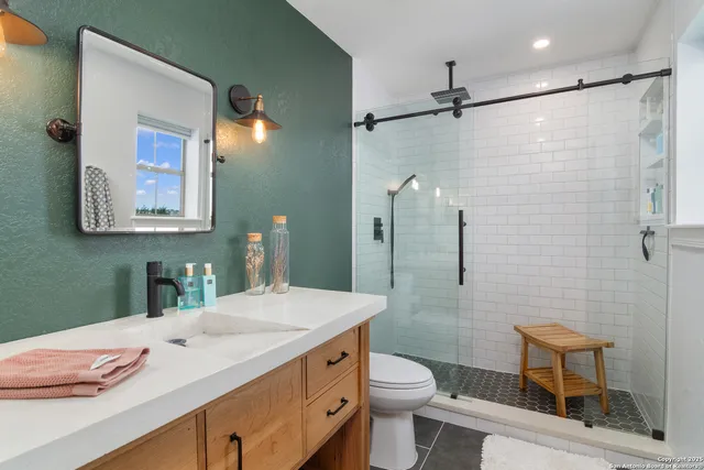 a bathroom with a granite countertop sink toilet and shower