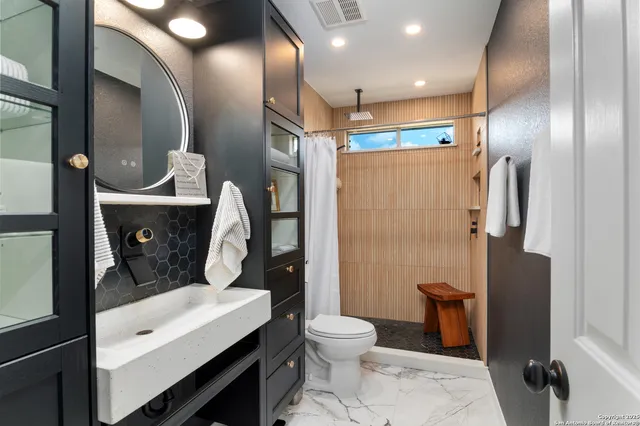 a bathroom with a toilet sink and shower