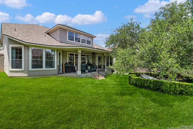 a view of a big house with a big yard and large trees