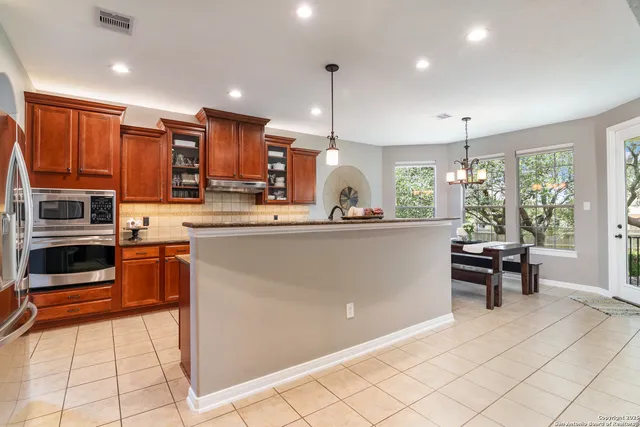 a kitchen with stainless steel appliances kitchen island granite countertop a refrigerator and a stove top oven