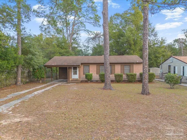 a front view of a house with a yard and trees