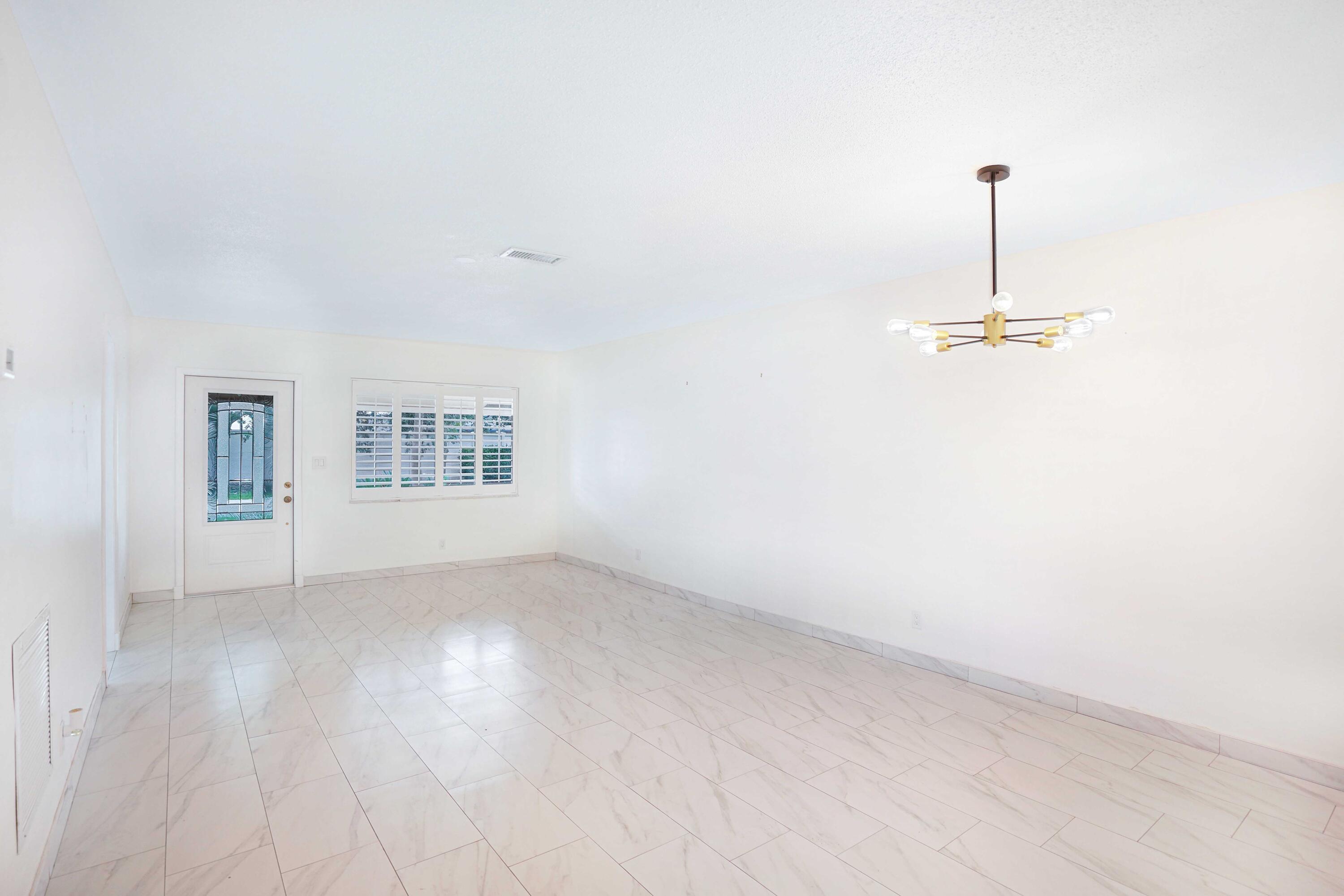 5100 Northeast 22nd Avenue Lighthouse Point, FL 33064 - Photo 11 of 31 an empty room with windows and ceiling fan