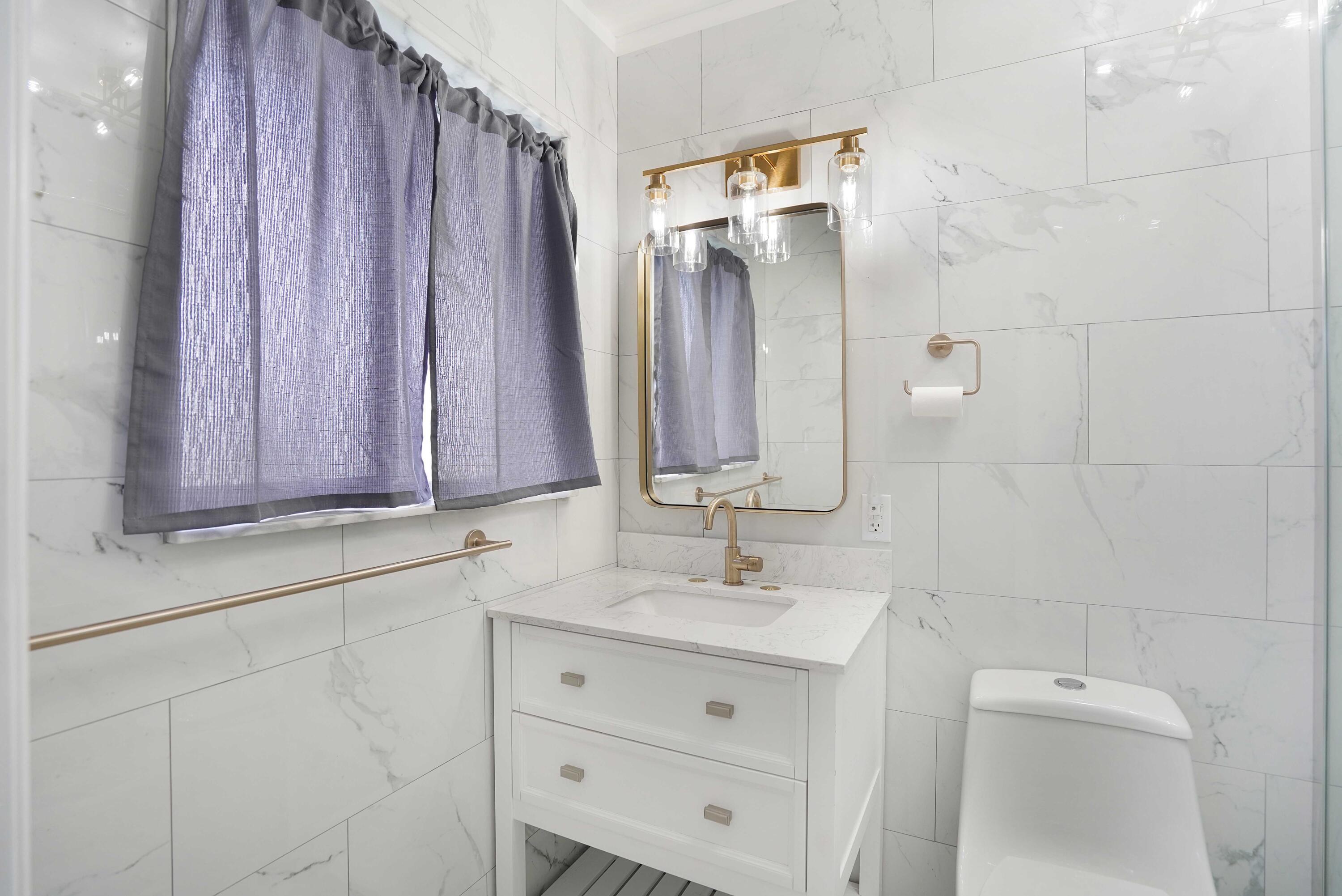 5100 Northeast 22nd Avenue Lighthouse Point, FL 33064 - Photo 13 of 31 a bathroom with a sink a mirror and a shower