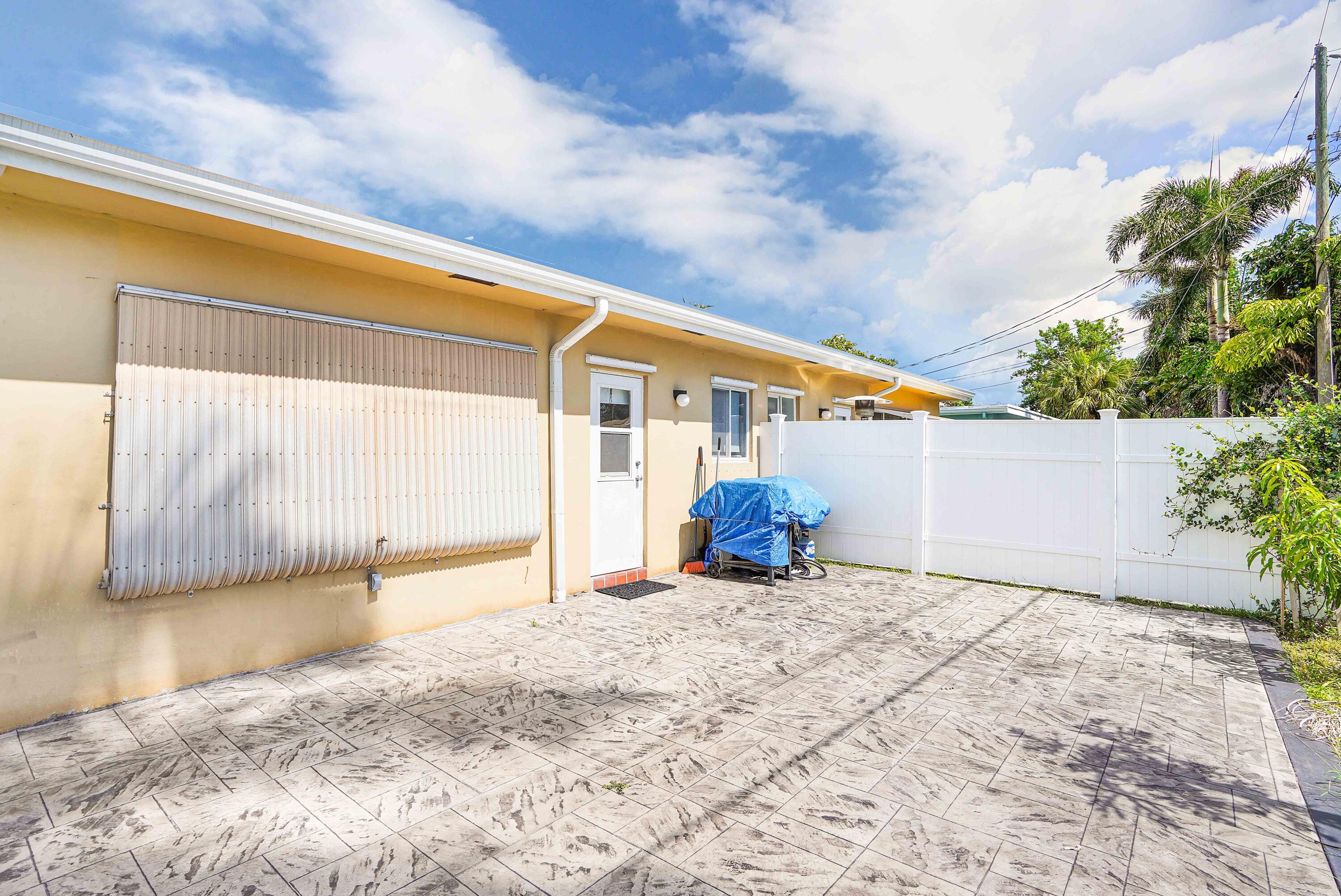 5100 Northeast 22nd Avenue Lighthouse Point, FL 33064 - Photo 16 of 31 a view of a house with a backyard and a garage