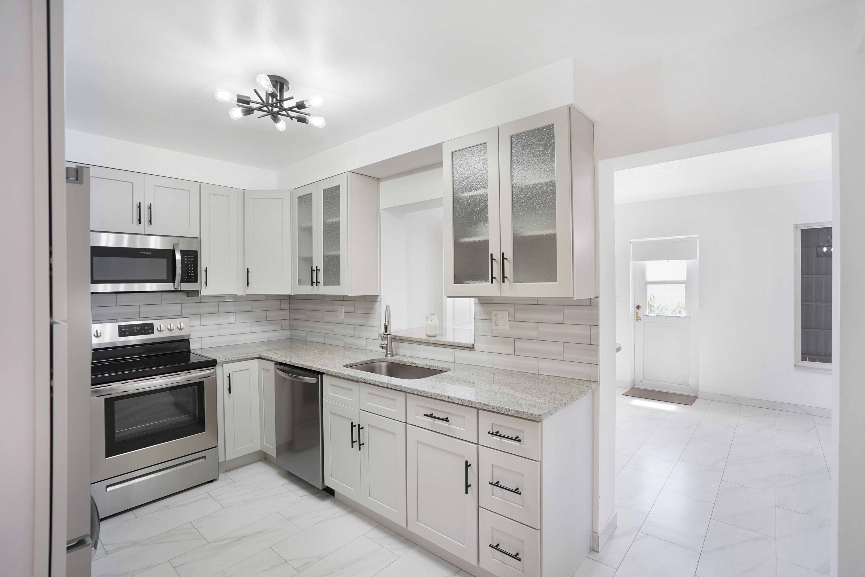 5100 Northeast 22nd Avenue Lighthouse Point, FL 33064 - Photo 20 of 31 a kitchen with cabinets stainless steel appliances and wooden floor