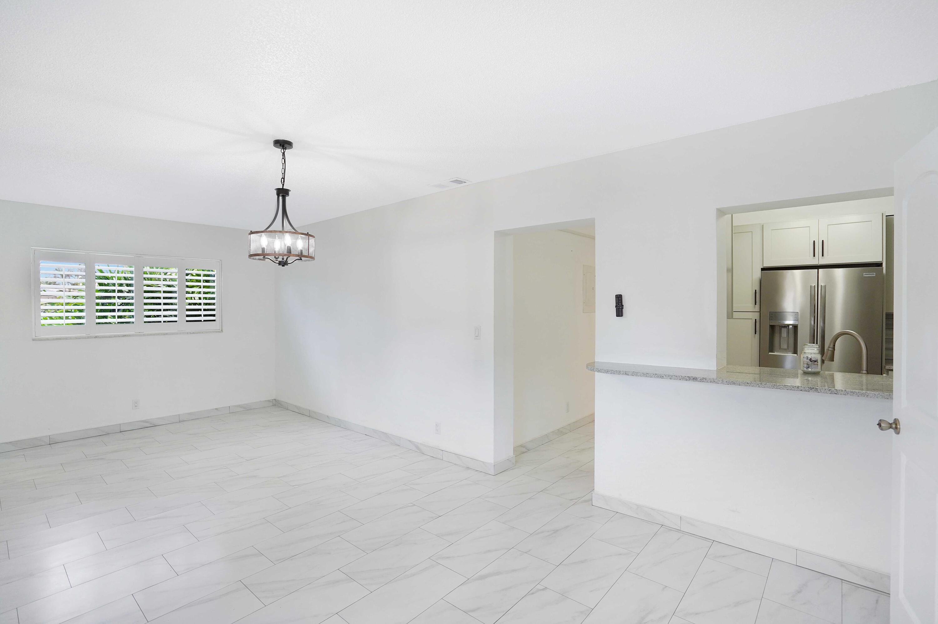 5100 Northeast 22nd Avenue Lighthouse Point, FL 33064 - Photo 22 of 31 an empty room with a window and chandelier